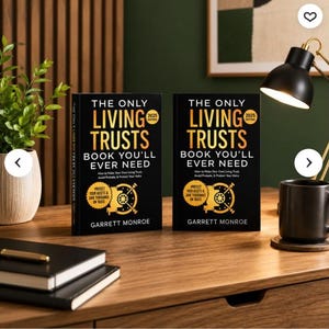 May include: Two identical black books titled The Only Living Trusts Book You'll Ever Need by Garrett Monroe, 2025 Edition. The covers feature gold text and a gold vault graphic. The books are displayed on a wooden desk with a black lamp and notebooks.
