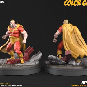 Könnte beinhalten: Eine 3D-gedruckte Figur des Charakters Hyperion, dargestellt in Vorder- und Rückansicht. Die Figur trägt einen roten Anzug mit goldenem Emblem, goldene Hose, Stiefel und einen gelben Umhang, stehend auf einem 50mm Sockel mit Trümmern.