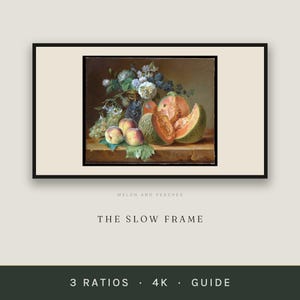 Puede incluir: Un bodegón enmarcado titulado MELON AND PEACHES de THE SLOW FRAME. La obra representa un jarrón oscuro lleno de flores blancas y azules, uvas verdes, tres melocotones y un melón cantalupo cortado que reposan sobre una superficie de madera.