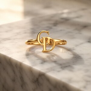 Custom initial ring featuring two connected letters in gold, romantic personalized gift for girlfriend and meaningful couple jewelry.