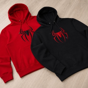 Può includere: Una felpa con cappuccio rossa con un emblema di ragno nero e una felpa con cappuccio nera con un emblema di ragno rosso. Entrambe le felpe presentano maniche lunghe, una tasca a marsupio frontale e cordini abbinati con punte in metallo.