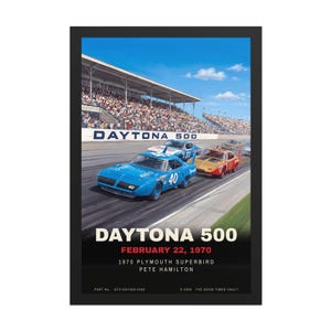 May include: A framed poster depicting the 1970 Daytona 500 race with a blue number 40 Plymouth Superbird leading a red car on a track. The text reads DAYTONA 500, FEBRUARY 22, 1970, 1970 PLYMOUTH SUPERBIRD, PETE HAMILTON, and THE GOOD TIMES VAULT.
