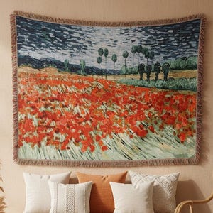 Puede incluir: Un tapiz de pared tejido rectangular que presenta una vibrante pintura de paisaje impresionista de un campo de amapolas rojas bajo un cielo oscuro y texturizado. El tapiz tiene un borde deshilachado y muestra ricos colores rojo, verde y azul.