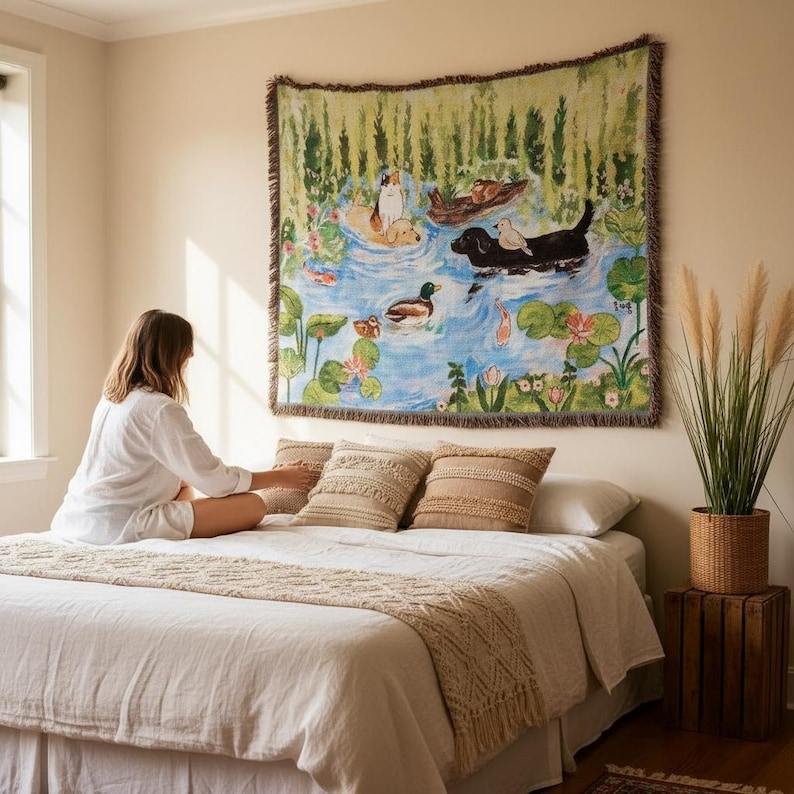 May include: A rectangular woven wall tapestry featuring a colourful illustration of dogs and ducks swimming in a pond with lily pads and green reeds. The scene includes a black dog, a golden dog, and a calico cat, all rendered in a painterly style.