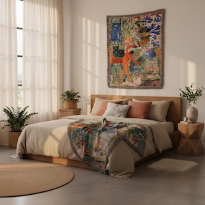 May include: A woven throw blanket featuring a colorful, abstract artistic print with human figures and organic shapes, displayed as a wall tapestry and draped over a bed. The blanket has a fringed edge and a multi-colored palette of red, blue, and green.