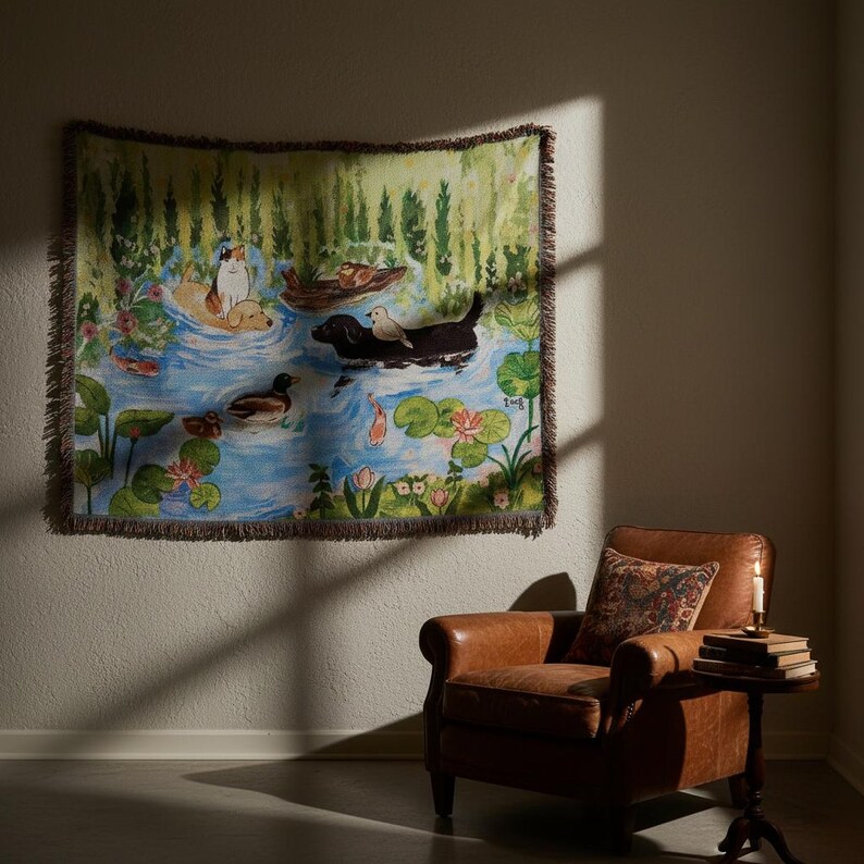 May include: A woven tapestry blanket featuring a colourful illustration of a pond scene with a calico cat, a golden dog, a black dog, and various ducks swimming among lily pads, lotus flowers, and green reeds, finished with a fringed edge.