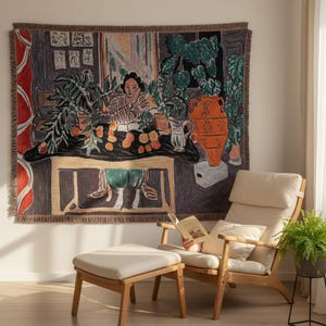 Può includere: Un arazzo da parete tessuto che raffigura una scena artistica colorata con una persona seduta a un tavolo con piante in vaso, un grande vaso arancione e frutta. Il design include una tenda rossa e uno sfondo scuro con quadri incorniciati.