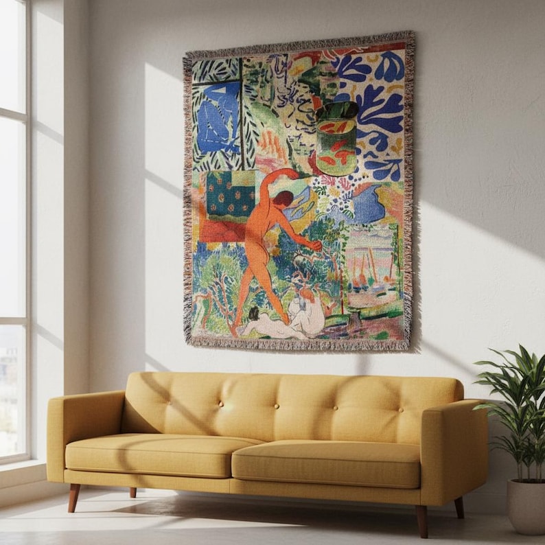 May include: A rectangular woven throw blanket featuring a vibrant, multi-colored abstract art print with figures, foliage, and geometric shapes in shades of blue, orange, green, and yellow, finished with a fringed edge on all four sides.