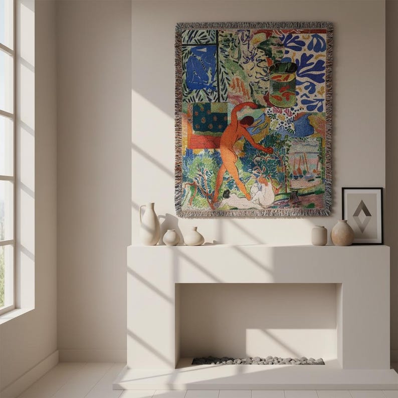 May include: A rectangular woven throw blanket featuring a vibrant, multi-colored collage of abstract shapes, figures, and a goldfish bowl. The tapestry has a fringed edge and displays a complex composition of blue, orange, green, and white patterns.