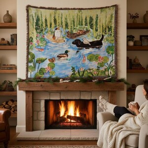 May include: A woven tapestry wall hanging featuring a colourful pond scene with a cat, a dog, ducks, and koi fish swimming among lily pads and flowers. The rectangular textile has a fringed edge and displays a vibrant landscape illustration.