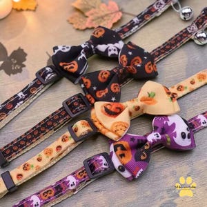 Può includere: Quattro collari per animali domestici con papillon a tema Halloween. I collari presentano cinturini in tessuto nero, beige e viola con stampe di zucche, fantasmi e pipistrelli. Ogni collare è dotato di una fibbia in plastica nera.