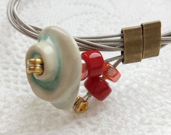 Guitar string bracelet with handmade ceramic flower button and glass beads