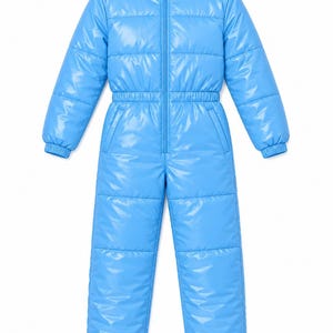 Op de afbeelding: Een felblauw, eendelig skipak met lange mouwen en een glanzende, gewatteerde afwerking. Het kledingstuk is voorzien van een ritssluiting aan de voorzijde, een elastische taille en een met witte stof gevoerde capuchon met zwarte koordstoppers.
