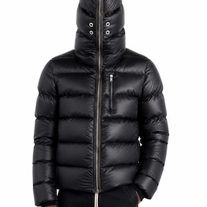 May include: A black puffer jacket with a high-neck hood that zips up to cover the face, featuring a full-length front zip, a single vertical zipped chest pocket, and two silver-toned eyelet vents on each side of the hood's face opening.