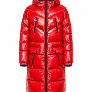 May include: A long, glossy red puffer coat featuring a quilted design, a hood with black trim, a full-length central black zipper, two zippered chest pockets, and two lower flap pockets with black accents. The cuffs are finished with black elastic trim.