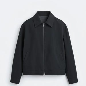 May include: A solid black zip-up jacket featuring a classic pointed collar, long sleeves with cuffs, and two slanted front pockets. The garment is constructed with a central silver-toned metal zipper that extends from the hem to the collar.