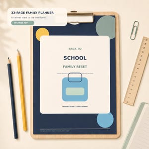 Könnte beinhalten: Ein 32-seitiger Familienplaner auf einem Holz-Klemmbrett mit Metallclip. Das Cover ist dunkelblau mit einem cremefarbenen Zentrum und zeigt den Text "BACK TO SCHOOL FAMILY RESET" sowie eine blaue Grafik. Enthält zwei Stifte und ein Lineal.