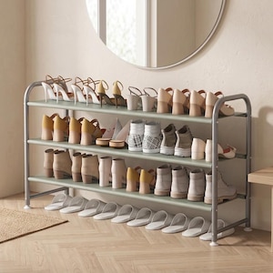 May include: A three-tier shoe rack with a grey metal frame and sage green shelves. The rack is filled with various types of footwear, including high-heeled sandals, ankle boots, sneakers, and white slippers arranged neatly across the three levels.