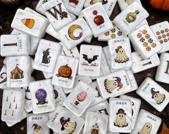 May include: A collection of white rectangular mahjong tiles featuring Halloween-themed illustrations including ghosts, pumpkins, bats, candy corn, and crystal balls. Each tile displays a number or the word Joker, Flower, Soap, Red, or Green.