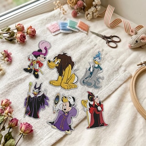 May include: Six embroidered patches featuring cartoon characters dressed as villains. The designs include a mouse as Captain Hook, a dog as a lion, a duck as Hades, a duck as Maleficent, a mouse as the Evil Queen, and a mouse as Jafar.