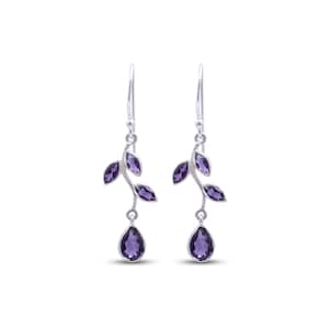 May include: A pair of silver drop earrings featuring a branch-like design with two small marquise-cut purple amethyst stones and one larger pear-cut purple amethyst stone at the base, suspended from a simple silver hook wire finding.