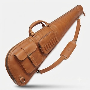 Può includere: Una custodia per fucile in pelle color cuoio con maniglia superiore, tracolla regolabile con sezione imbottita, scomparto principale con cerniera e due tasche esterne. Una tasca ha una chiusura a fibbia, l'altra sei passanti per cartucce.