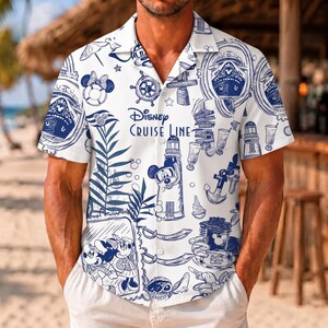 May include: A white short-sleeved button-down shirt featuring a blue nautical-themed print with the text Disney Cruise Line. The pattern includes illustrations of cruise ships, anchors, lighthouses, palm leaves, and cartoon characters.