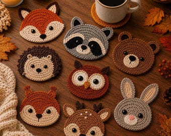 May include: A collection of eight round crochet coasters featuring animal faces including a fox, raccoon, bear, hedgehog, owl, squirrel, deer, and rabbit. Each coaster is crafted with yarn in shades of brown, orange, gray, and cream with black eyes.