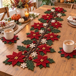 Könnte beinhalten: Ein gehäkelter Tischläufer und zwei passende Untersetzer mit roten Weihnachtssternen mit gelben Mitten, dunkelgrünen Stechpalmenblättern, kleinen roten Beeren und weißen Schneeflocken-Akzenten, die in einem rankenartigen Muster auf einem Holztisch angeordnet sind.