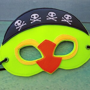 May include: A green and black felt mask with a black skull and crossbones design on the top and a red and yellow eye mask design.