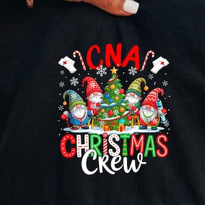 May include: A black t-shirt featuring a graphic of three gnomes decorating a Christmas tree. The design includes the text CNA CHRISTMAS CREW, nurse caps, candy canes, and snowflakes in red, green, blue, and white colors on a black background.