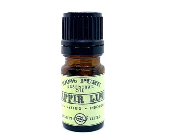 May include: A small amber glass bottle of essential oil with a black cap. The label reads "100% Pure Essential Oil" and "Kaffir Lime". The bottle is labeled "Citrus Hystrix" and "Indonesia".