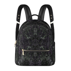 Puede incluir: Una mochila con un patrón moteado oscuro en tonos negro, morado intenso y verde bosque. La bolsa incluye correas negras para los hombros con herrajes dorados, un asa superior y un bolsillo frontal con cremallera y tirador dorado.