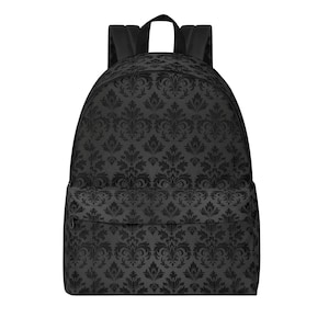 May include: A black backpack featuring a repeating dark grey damask pattern across the entire exterior. The bag includes a large main compartment, a smaller front zippered pocket, and two black shoulder straps attached to the top handle.