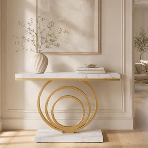May include: A console table featuring a rectangular white marble top with grey veining, supported by a gold-toned metal base composed of three concentric circular rings, resting on a matching rectangular white marble base with grey veining.