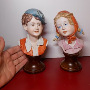 Par Capodimonte-byster, porslinspojke och flicka på träbas, samlarfigurer av Capodimonte
