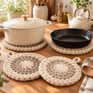 Puede incluir: Dos salvamanteles redondos y gruesos de ganchillo con un patrón concéntrico de hilo color crema, beige y marrón claro. Cada salvamanteles tiene un pequeño lazo en el borde para colgar. Estos accesorios de cocina texturizados están hechos a mano.