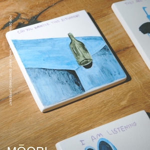 May include: A square white ceramic tile featuring a hand-painted illustration of a green glass bottle resting on a blue surface. The text "CAN YOU HANDLE THIS SITUATION?" is written in purple ink at the top of the tile, which has a glossy finish.