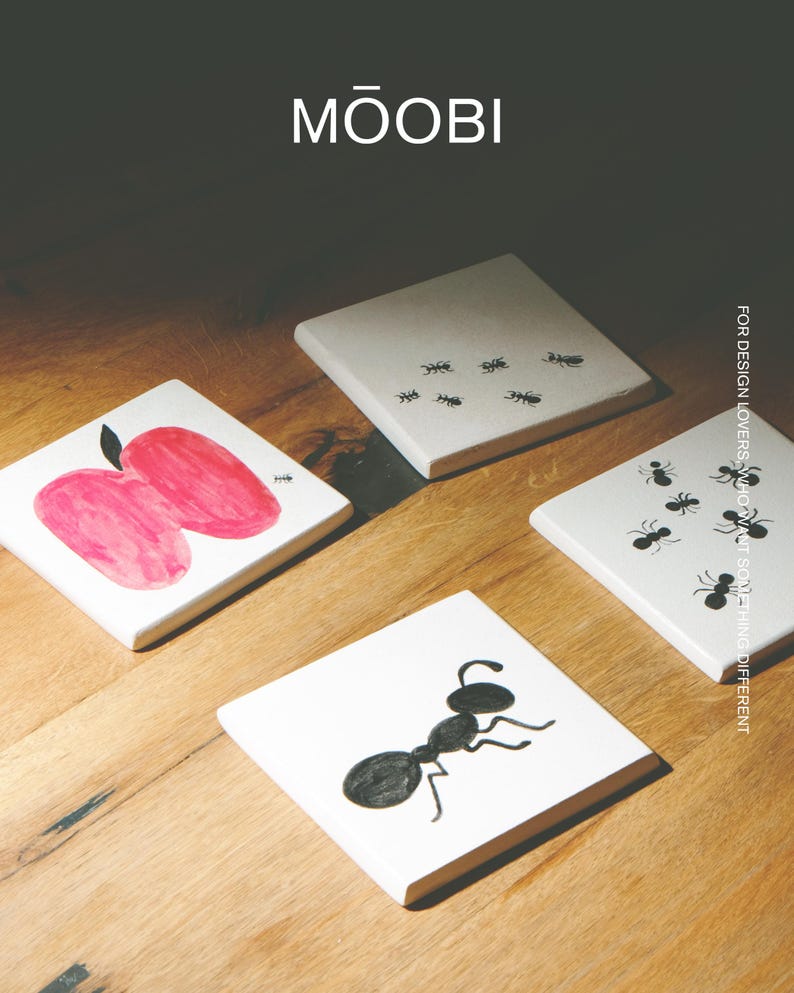Pu&ograve; includere: Quattro sottobicchieri quadrati bianchi con grafiche nere e rosse. Uno presenta una mela rossa, uno una grande formica nera e due presentano motivi di piccole formiche nere. Il testo MŌOBI e FOR DESIGN LOVERS, WHO WANT SOMETHING DIFFERENT &egrave; visibile.