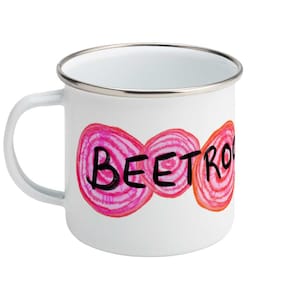 Op de afbeelding: Een witte emaille mok met een zilverkleurige rand en handvat. De voorzijde toont een afbeelding van drie schijfjes rode biet in roze en oranje tinten, met de zwarte handgeschreven tekst BEETROOT over het midden van de illustraties.