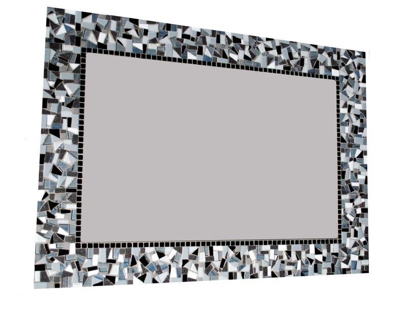 Puede incluir: Un espejo rectangular con un marco decorativo hecho de peque&ntilde;as piezas irregulares de mosaico negro, blanco y gris.