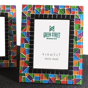 May include: Two photo frames with colorful mosaic tile borders. The frames have a black inner border and white space for photos. The text "GREEN STREET MOSAICS" and "4 x 6 OR 5 x 7 PHOTO FRAME" are visible on the frames.