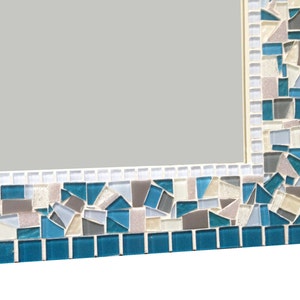 May include: A rectangular mirror with a mosaic frame. The frame is made of small, irregular pieces of glass in shades of blue, grey, and white.