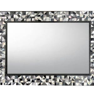 Puede incluir: Un espejo rectangular con un marco de mosaico blanco y negro. El marco est&aacute; hecho de peque&ntilde;os trozos irregulares de vidrio.
