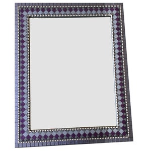 May include: A rectangular mirror with a decorative frame. The frame is made of a mosaic of small squares in shades of purple and gray.