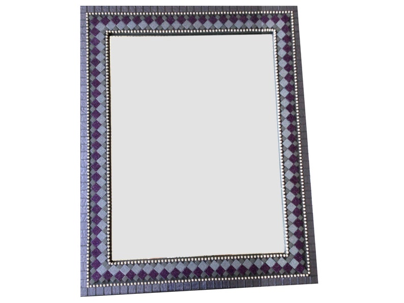 May include: A rectangular mirror with a decorative frame. The frame is made of a mosaic of small squares in shades of purple and gray.