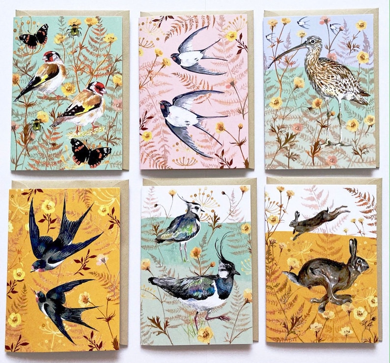 May include: Set of six greeting cards featuring colorful illustrations of birds, butterflies, and other wildlife against a backdrop of green and yellow foliage.