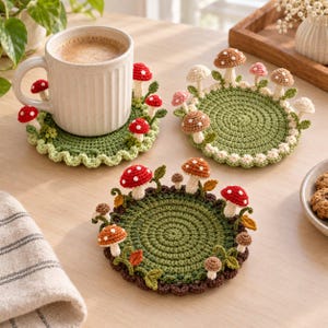 May include: Three round, green crocheted coasters featuring various small, three-dimensional mushrooms in shades of red, brown, pink, and cream. The coasters have textured, scalloped edges and are decorated with small crocheted leaves and vines.