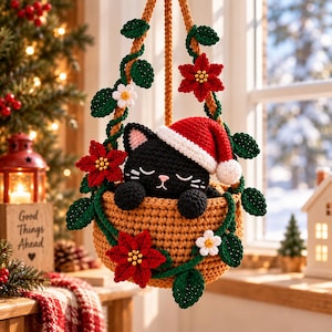 May include: A crocheted black cat wearing a red and white Santa hat, nestled inside a tan hanging basket. The basket is decorated with crocheted green leaves, red poinsettia flowers with yellow centers, and small white flowers with yellow centers.