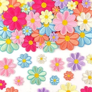 May include: A collection of embroidered flower patches in various sizes and colors, including shades of pink, blue, yellow, orange, purple, and white. Each patch features a circular yellow center surrounded by eight rounded petals.